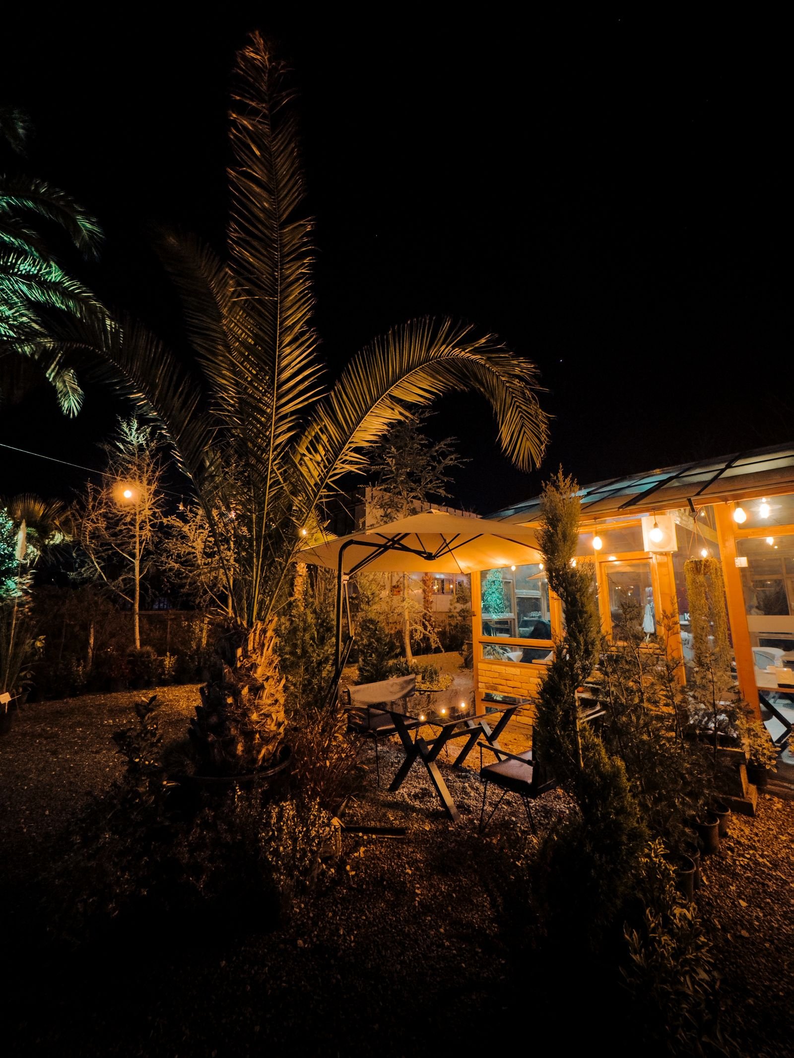 Outdoor patio seating area glowing with warm string lights in the evening
