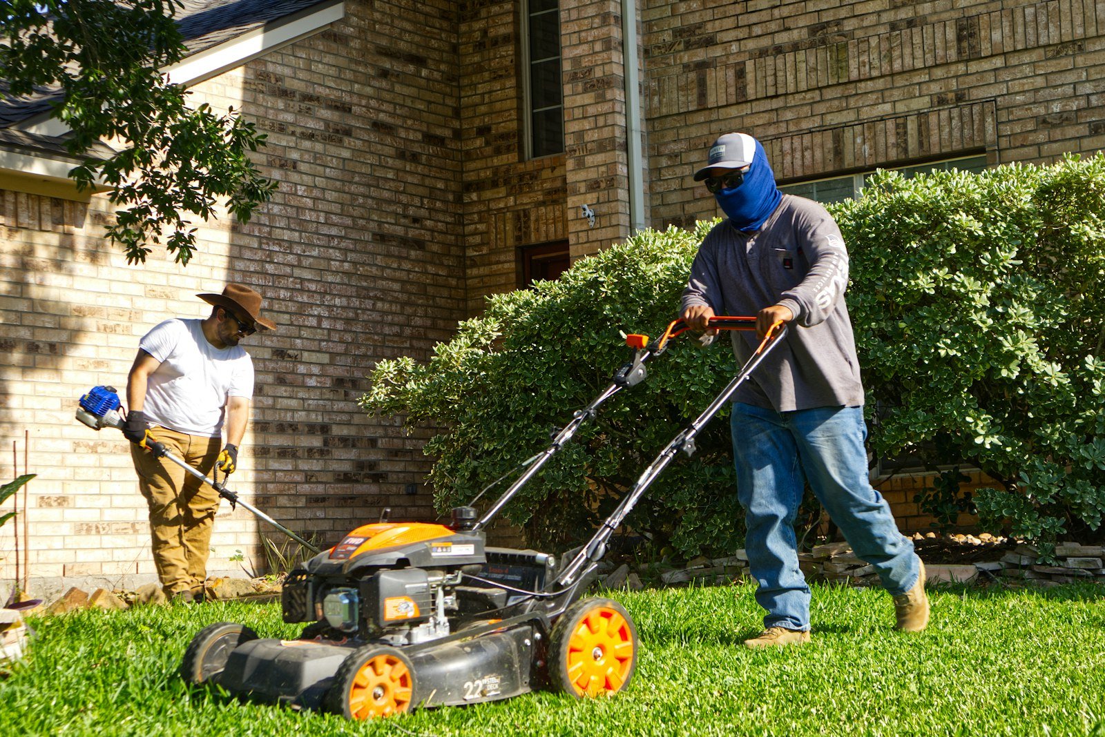 Lawn care crew mowing and trimming a residential lawn